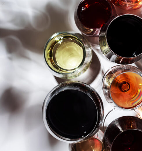Red, white, rose wines in glasses in assortment on white backgro Red, white, rose wines in glasses in assortment on white background, top view. Wine bar, shop, winery, outdoor wine tasting concept. Hard light and harsh shadows