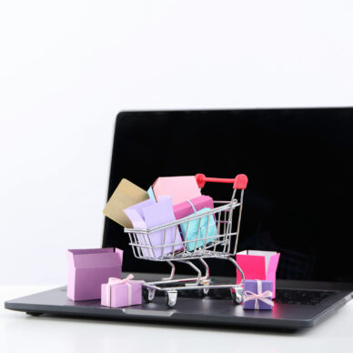 Shopping cart with packages, thumbnail on laptop.