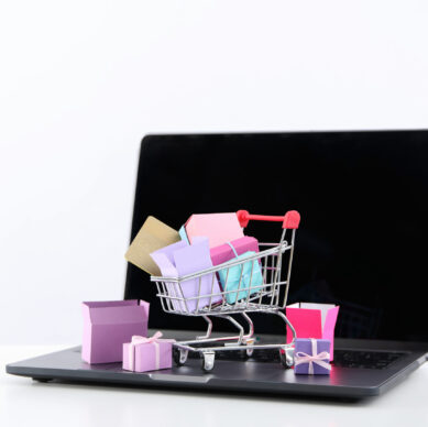 Shopping cart with packages, thumbnail on laptop.