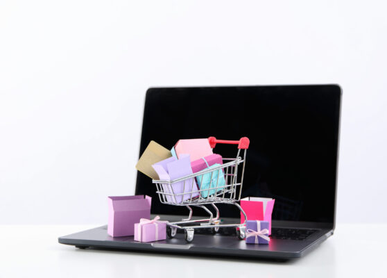 Shopping cart with packages, thumbnail on laptop.